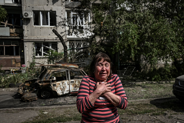 A woman reacts outside a damaged building after a strike in the city of Slovyansk at the eastern Ukrainian region of Donbas on Tuesday (AFP photo)