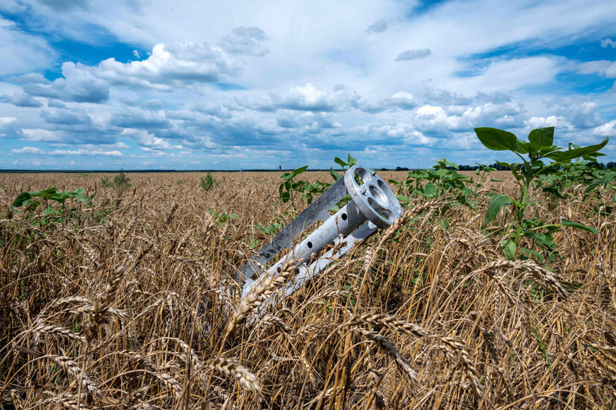 A fragment of a rocket from a multiple rocket launcher is seen embedded in the ground on a wheat field in the Ukrainian Kharkiv region on July 19, 2022, amid Russian invasion of Ukraine (AFP photo)