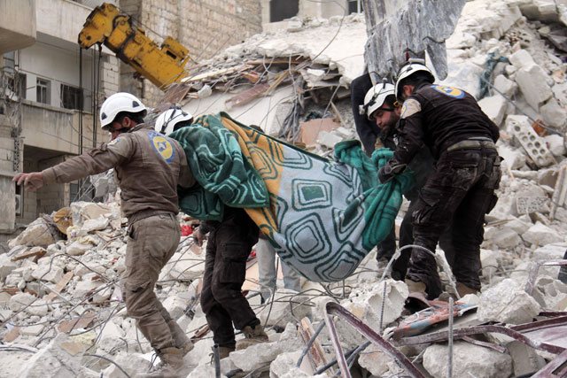 Syrian civil defence volunteers, known as the White Helmets, carry a body retrieved from the rubble following a reported government air strike on the Syrian town of Ariha, in the northwestern province of Idlib, on Monday (AFP photo)