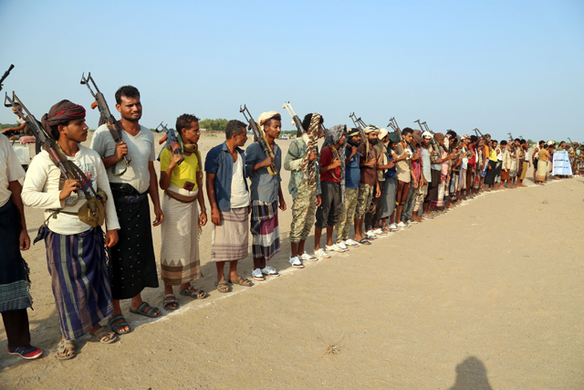 Armed militants gather for a protest against Yemen's Houthi rebels in the Khokha region of the country's war-ravaged western province of Hodeida on Tuesday, demonstrating against the destruction of farms and civilian property in the Bait Al Faqih district south of Hodeida (AFP photo)
