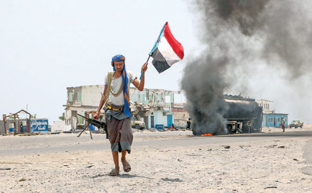 A Yemeni fighter walks with a separatist flag in southern Yemen on August 30 (AFP photo)