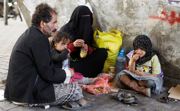 A homeless family eats lunch along a street in Sanaa, Yemen, on Thursday (Reuters photo)