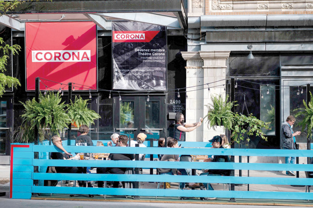 In this file photo, patrons enjoy an evening drink and dinner on the terrace of the Burgundy Lion as restaurants start reopening outdoor dining in Montreal, Canada, on May 28 (AFP photo)