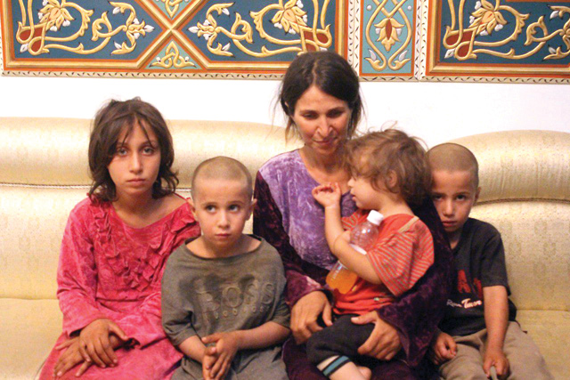 A woman and four children among the six released of 27 Druze hostages held by the Daesh group in a prisoner swap and ransom, upon their arrival at a government-controlled building in Syria's southern city of Sweida, on Saturday  (AFP photo)