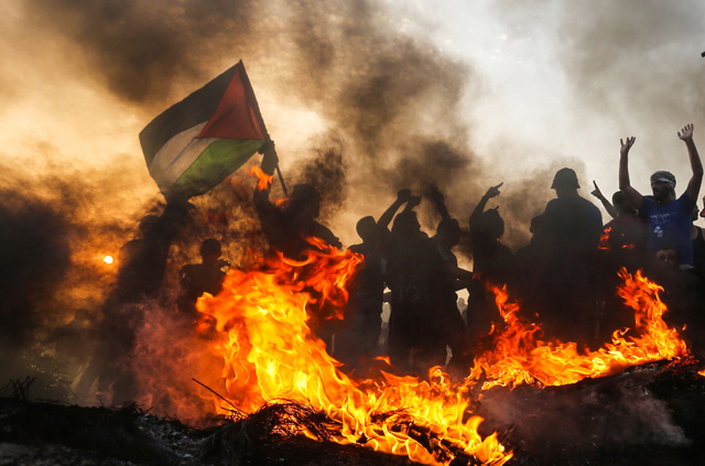 A Palestinian protester waves a national flag during a demonstration on the beach near the maritime border with Israel, in the northern Gaza Strip, on Monday  (AFP photo)