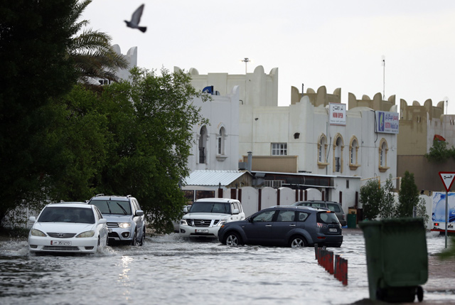 Motorists drive through a flooded street in the Qatari capital Doha, following heavy rainfall, on Saturday (AFP photo)