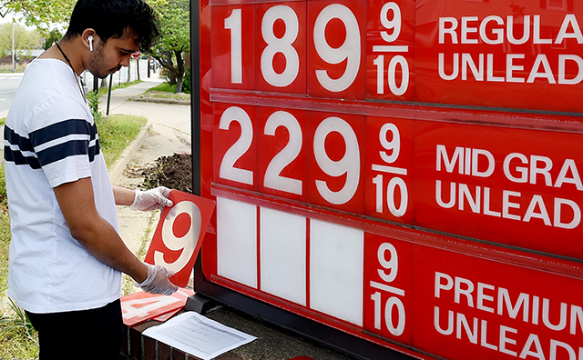 An employee of a gas station in Arlington, Virginia, adjusts gasoline pump prices on April 21, 2020 (AFP photo)