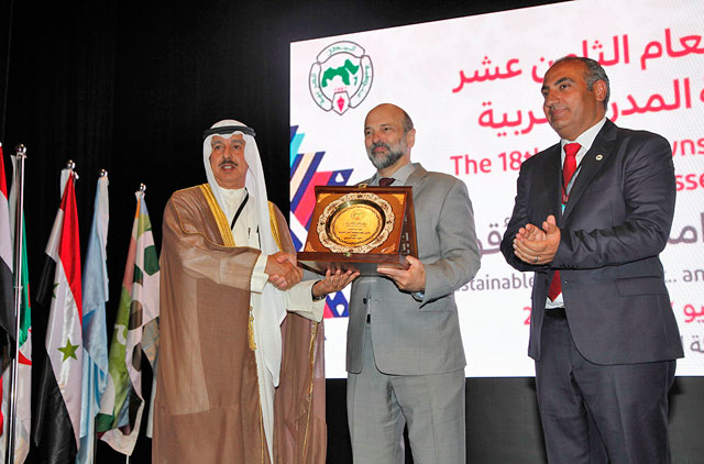 Prime Minister Omar Razzaz accepts a plaque on behalf of His Majesty King Abdullah on Monday (Petra photo)