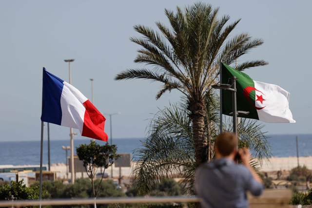 This photo taken on Thursday shows French and Algerian national flags ahead of the arrival of French president in Algiers for an official visit (AFP photo)