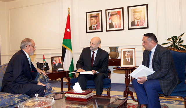 Prime Minister Omar Razzaz receives a copy of the Audit Bureau's 2018 report, which recorded a total of 3,531 violations (Petra photo)