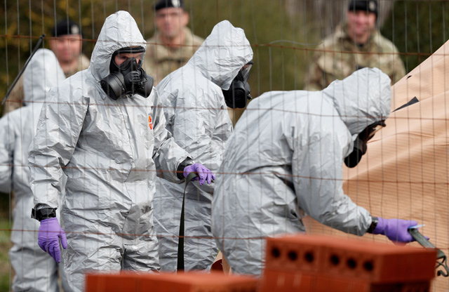 British military personnel wearing protective overalls work to remove a vehicle connected to the March 4 nerve agent attack in Salisbury, from a residential street in Gillingham, southeast England, on Wednesday (AFP photo)