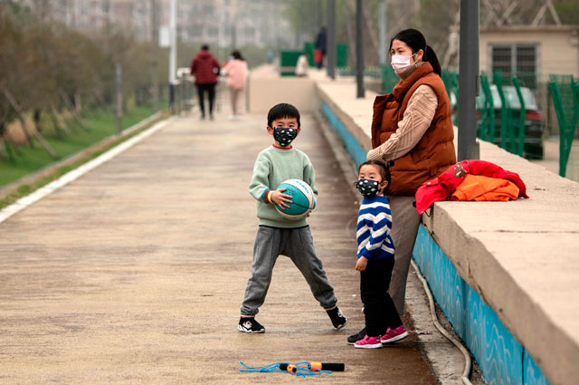 People wearing face masks are seen along a street in Jiujiang's central Jiangxi province on Saturday (AFP photo)