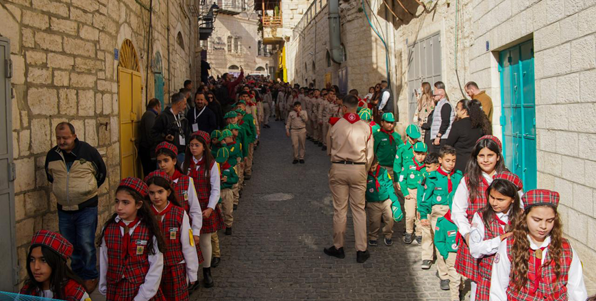 Palestinian scouts march through the streets, holding signs that read, ‘We want life, not death,” “Peace for Gaza,” and “Our children want to play and laugh’ (Photo courtesy of Latin Patriarch of Jerusalem)