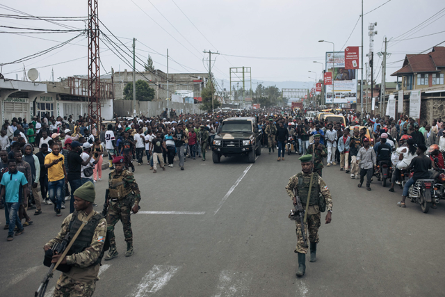 A military pick up truck is escorted by soldiers as residents run in a street in Goma on Thursday  (AFP photo)