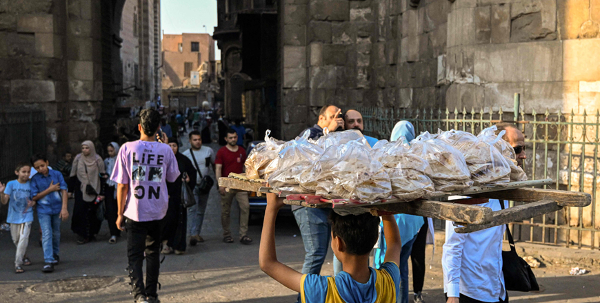 A young boy delivers freshly-baked bread in the Al Darb Al Ahmar district in the old quarters of Cairo on Tuesday (AFP photo)