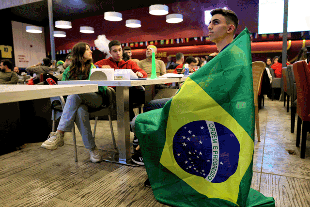 Lebanese watch a streaming broadcast of the FIFA World Cup 2022 at a cafe-restaurant in the area of Sabtiyeh, north of Beirut, on Monday (AFP photo)