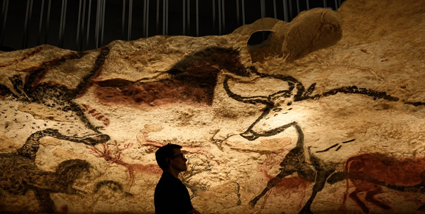 A visitors looks at a section of the life size Lascaux cave replica after a special immersive torch light visit on June 16, 2022 in Montignac (AFP photo)