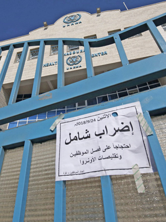 An Arabic sign reads: ‘Comprehensive strike’ attached on a closed gate of a health centre run by United Nations Relief and Works Agency during a strike of all UNRWA institutions in Rafah in the southern Gaza Strip, on Monday (AFP photo)