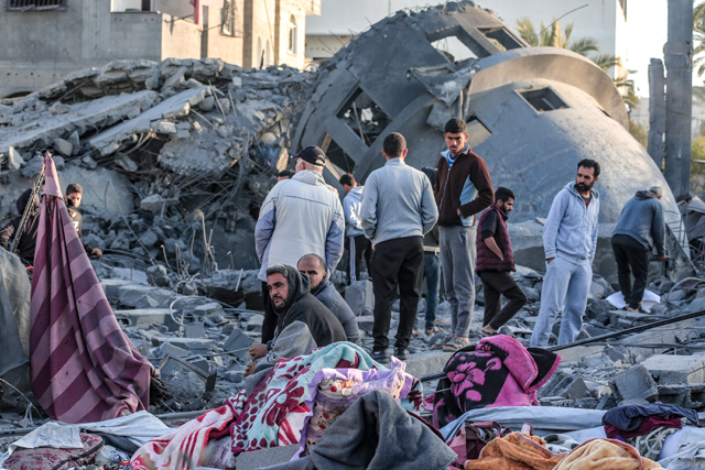 Palestinians stand amid the rubble of a mosque that was destroyed in Israeli strikes in Deir El Balah in central Gaza on Saturday (AFP photo)