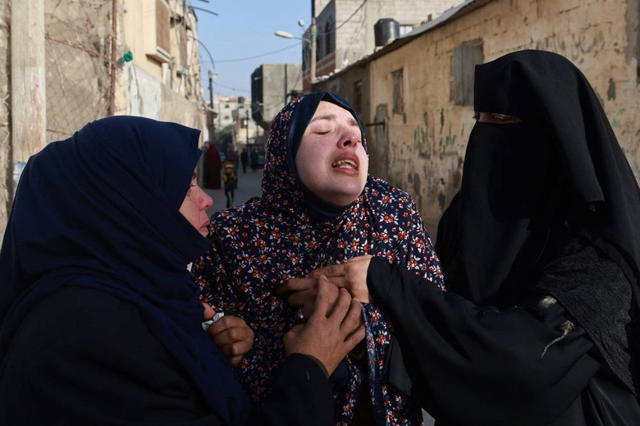 Rania Abu Anza (centre) the mother of twin babies Naeem and Wissam, killed in an overnight Israeli air strike, mourns their death ahead of their burial in Rafah in the southern Gaza Strip on Sunday (AFP photo)