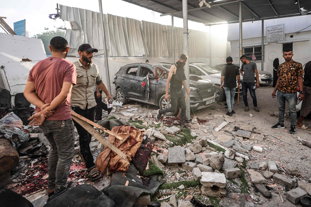 Palestinians inspect the aftermath of an Israeli strike on a building in Nuseirat on Saturday (AFP photo)