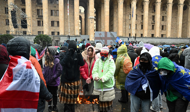 Protestors gather in front of the Georgian Parliament during a protest against the results of the last month's parliamentary elections, amid the first session of the new parliament, in Tbilisi on Monday (AFP photo)