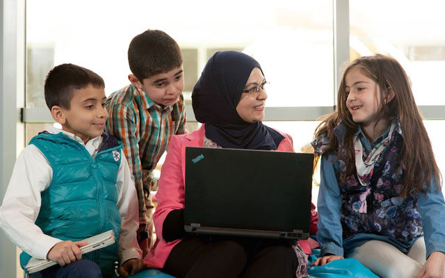 Hanan Khader sits with children who learn how to code with Hello World Kids in Amman recently (Photo courtesy of Hello World Kids)
