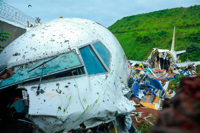 Officials inspect the wreckage of an Air India Express jet at Calicut International Airport in Karipur, Kerala, on Saturday (AFP photo)