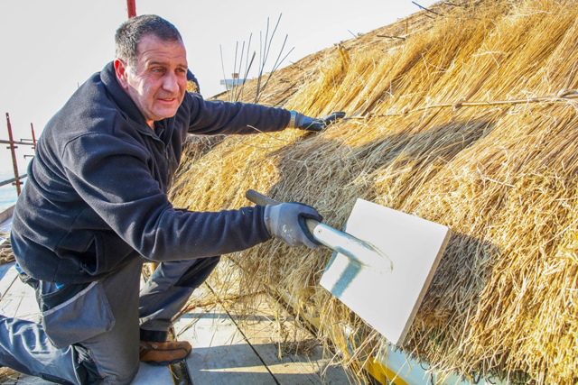Traditional Thatcher Ivor Kilpatrick from the Donegal Thatching school, works on the roof of a thatched cottage in Bunbeg, north western Ireland, on March 9 (AFP photo)