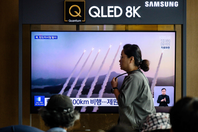 A woman walks past a television screen showing a news broadcast with file footage of a North Korean missile test, at a train station in Seoul on Wednesday (AFP photo)