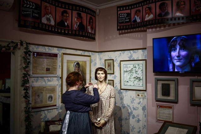 A regency actor who works at the Jane Austen Centre adjusts a waxwork model of Jane Austen, in Bath, Somerset (AFP photo)
