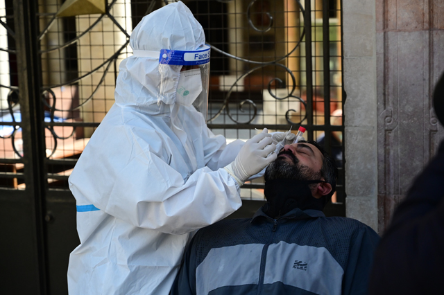 A health worker collects a sample from a man for a COVID-19 test in Amman in this photo taken on February 26, 2021 (Photo by Amjad Ghsoun)