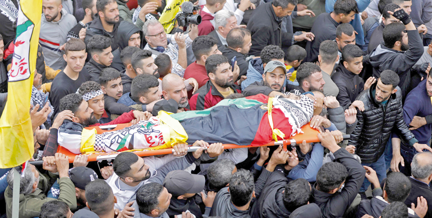Palestinian mourners carry the body of Raed Al Naasan, 21, who was killed during confrontations with Israeli forces the previous day, during his funeral in the village of Al Mughayyer, on Wednesday  (AFP photo)
