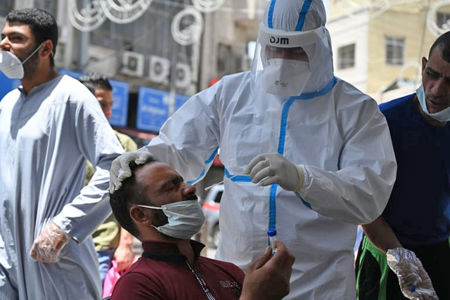 A healthcare worker collects a sample from a man during a coronavirus test in Amman in this recent photo. A total of 6,409 random virus tests were conducted on Sunday, bringing the cumulative number of coronavirus tests administered since the onset of the crisis to 692,760, according to authorities (Photo by Amjad Ghsoun)