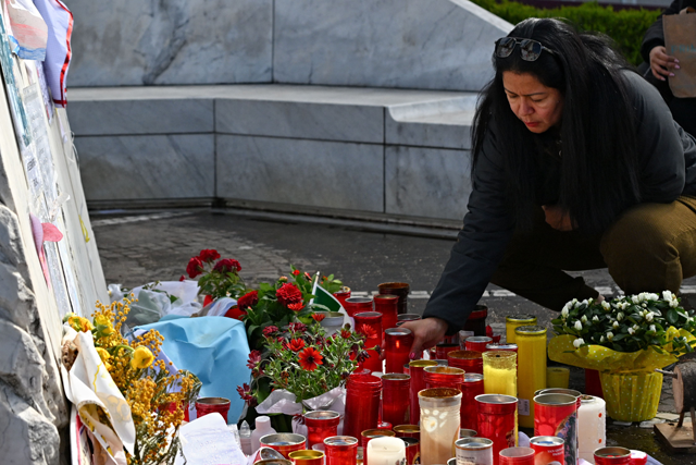 A woman lays a candle at the statue of John Paul II outside the Gemelli University Hospital where Pope Francis is hospitalised with pneumonia, in Rome today (AFP photo)