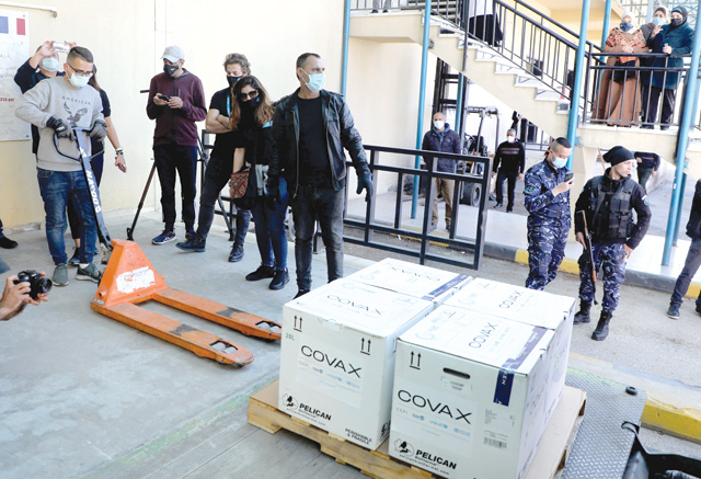 A worker unloads a refrigerated truck carrying the first delivery of coronavirus vaccine via the United Nations Covax programme supporting poorer areas, to be kept at Palestinian Authority's storage facility in the West Bank city of Nablus, on Wednesday (AFP photo)