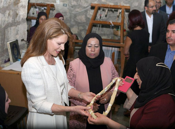 Her Majesty Queen Noor is seen looking at handcrafts made by women (Photo courtesy of Royal Court)
