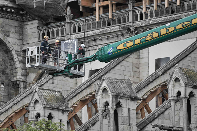 Workers take part in the dismantling operation of the scaffolding at the Notre-Dame Cathedral in Paris on Monday that was damaged in the April 15, 2019 blaze (AFP photo)