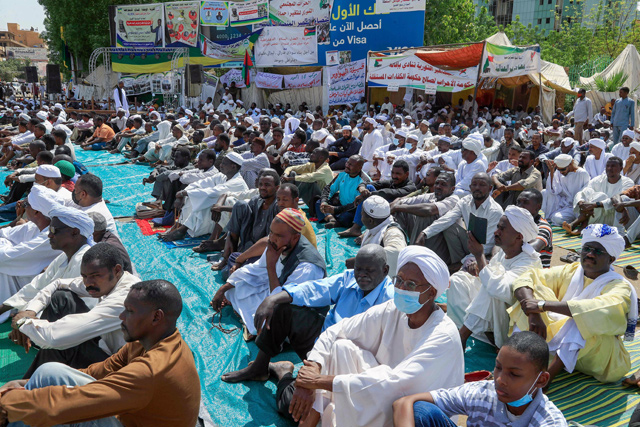 Sudanese pro-military protesters listen to the Friday prayer sermon, with the attendance of the minister of finance, in front of the presidential palace in the capital Khartoum (AFP photo)