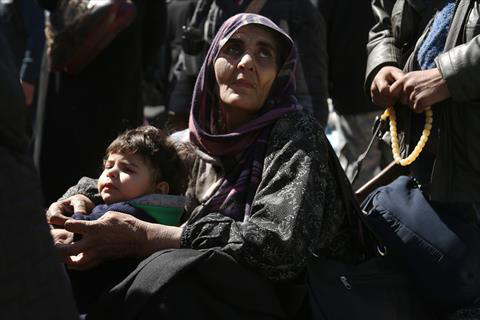 A Syrian woman and a child are seen in the village of Qalaat Al Madiq, some 45 kilometres northwest of the central city of Hama, on Monday, as evacuations from Eastern Ghouta continued following a deal that was announced earlier in the week (AFP photo)