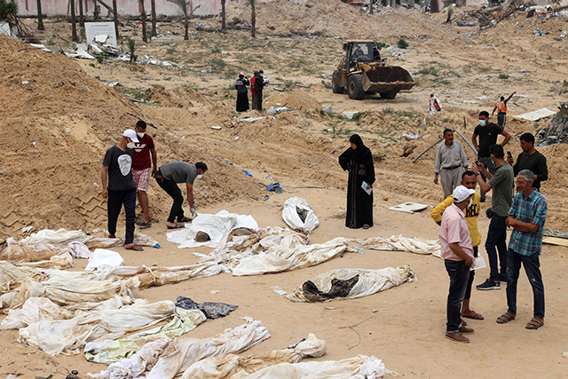 People gather near bodies lined up for identification after they were unearthed from a mass grave found in the Nasser Medical Complex in the southern Gaza Strip on Thursday (AFP photo)