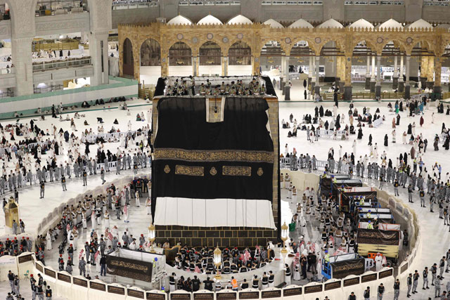 Saudi workers adjust the new Kiswa, the protective cover that engulfs the Kaaba which is made from black silk and gold thread and is embroidered with Koran verses, in Saudi Arabia's holy city of Mecca, on Saturday (AFP photo)