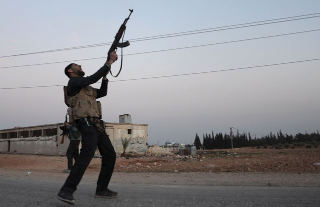 A Turkish-backed Syrian rebel fires off his gun in the northeastern border town of Al Bab on Thursday after they fully recaptured the town from the Daesh group (AFP photo)