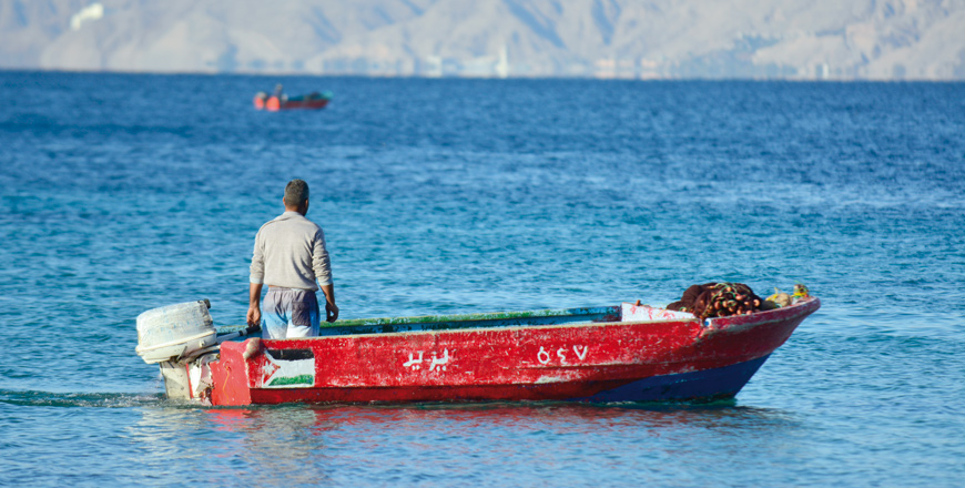 A fisherman is seen on his boat near the Aqaba coast in this photo dated December 16, 2017 (Photo by Amjad Ghsoun)