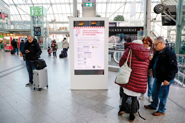 Passengers stand inside Lyon railway station in Paris on Sunday during a strike of state railway company SNCF employees over French government's plan to overhaul the country's retirement system, as part of a national general strike (AFP photo)