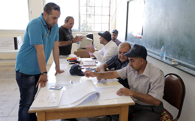 A voter waits for a polling station worker to verify his registration in Amman on Tuesday (Photo by Hassan Tamimi) 