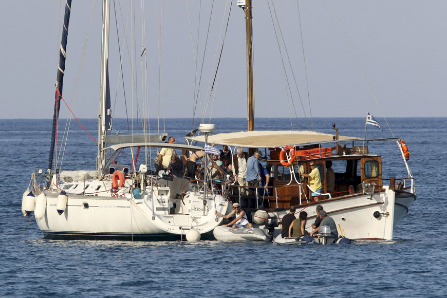 Pro-Palestinian activists embark on a sailing boat, to be part of a small flotilla that media reports say will try to challenge Israel's sea blockade of the Gaza Strip, in the open sea near Plaka on the island of Crete, Greece, on Friday (Reuters photo)