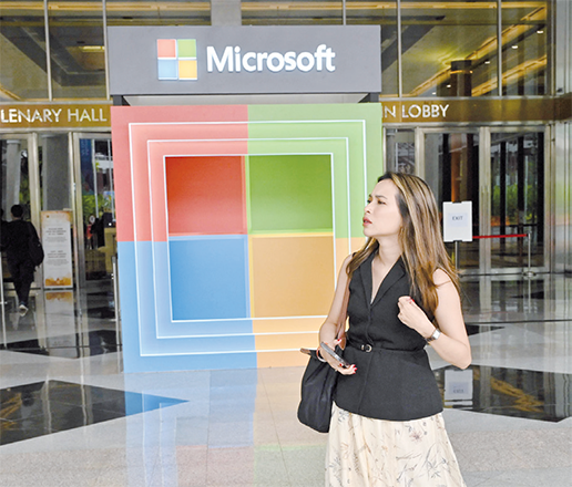A woman walks next to a logo of Microsoft during an event named Microsoft Build AI Day in Jakarta on Tuesday (AFP photo)