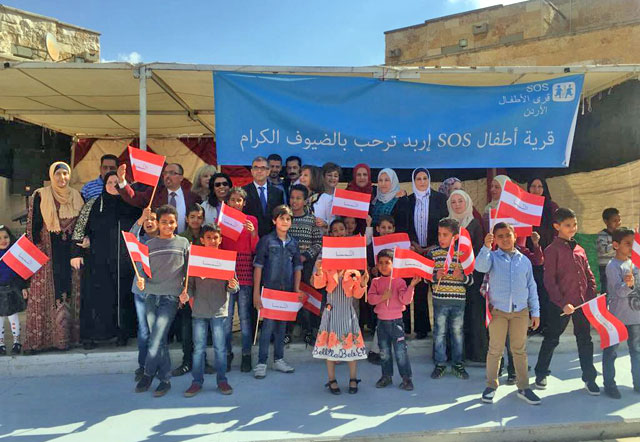 Children pose for a photo with Austrian flags on Thursday during a visit of Austrian Ambassador Michael Desser and his wife Nanete to the SOS Village in Irbid (Photo courtesy of SOS Villages)
