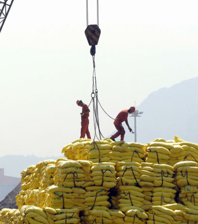 Workers unload goods waiting to be exported in a port in Lianyungang, east China's Jiangsu province, on Monday (AFP photo)